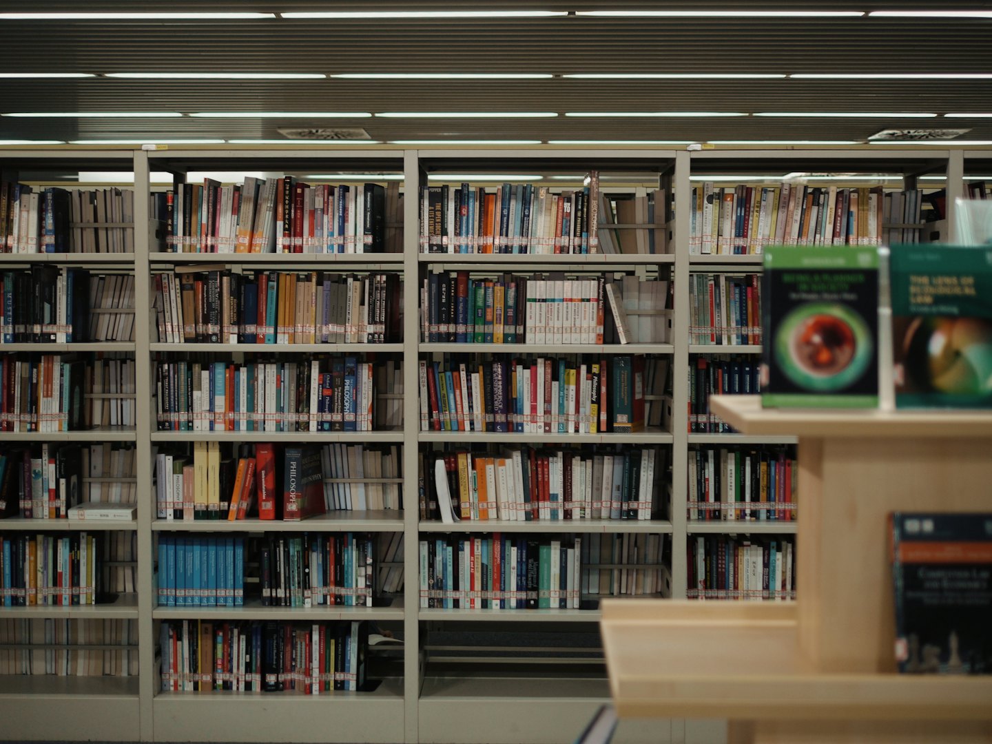 Metal bookshelves filled with books stand in a library.